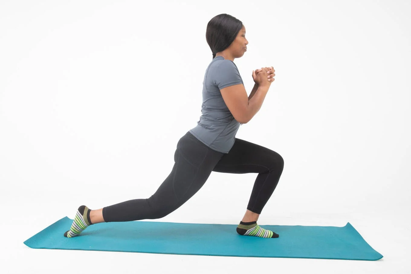 person performing a lunging exercise on a yoga mat