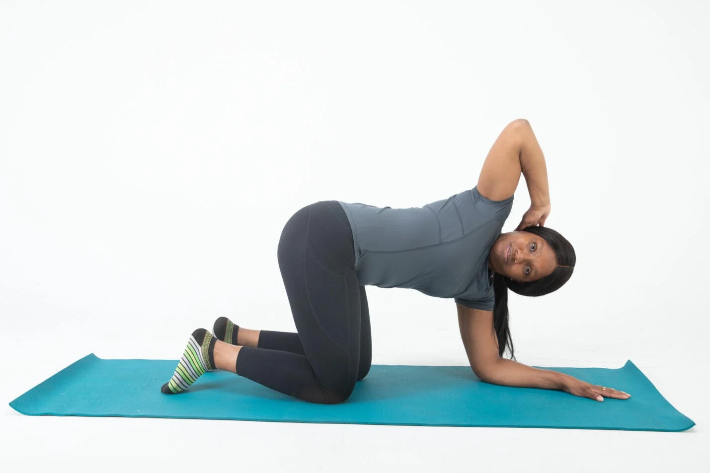 demonstration of a stretching exercise on a yoga mat