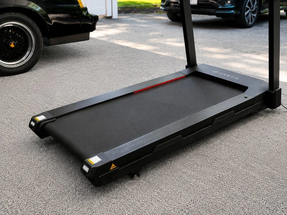 A modern treadmill on a gravel surface, featuring a sleek design and safety features.