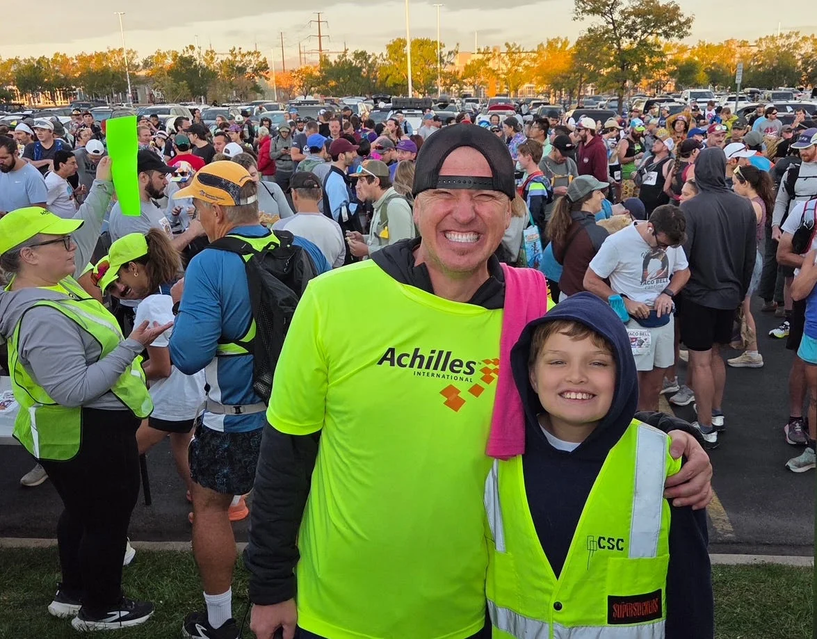 Two smiling individuals in bright vests among a crowd at an outdoor event, showcasing camaraderie and excitement. Two smiling individuals in bright vests among a crowd at an outdoor event, showcasing camaraderie and excitement.