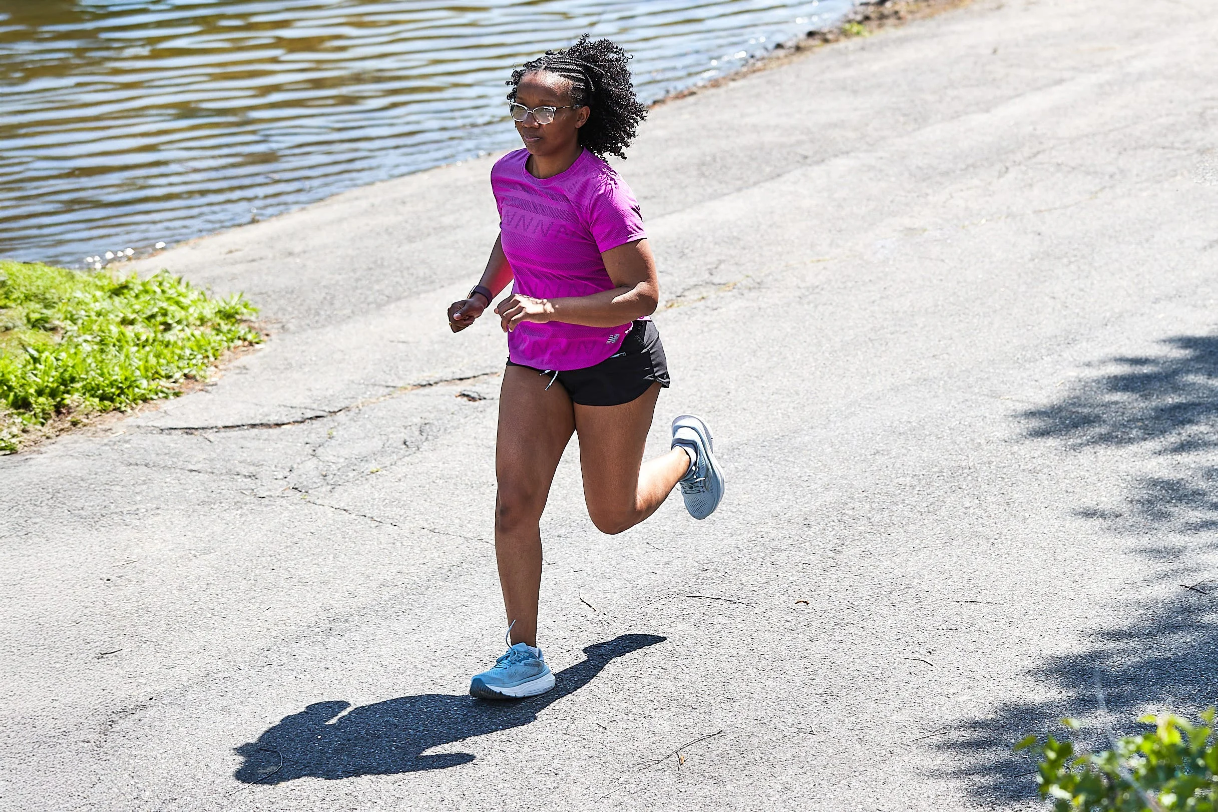 runner on asphalt path next to water runner on asphalt path next to water