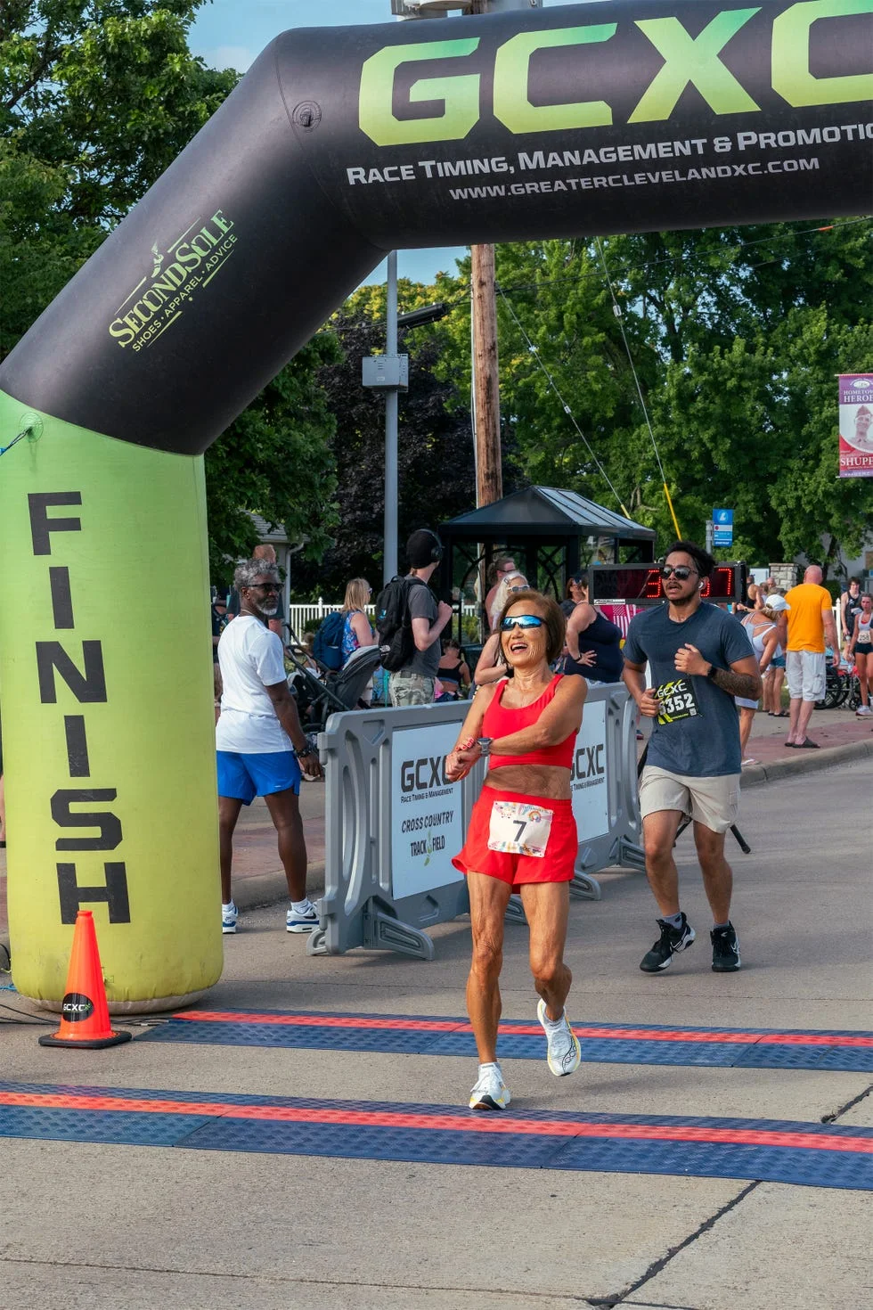 painsville, oh july 12 2025 jeannie rice (c) crossing the finishline of the johnnycake 5k.